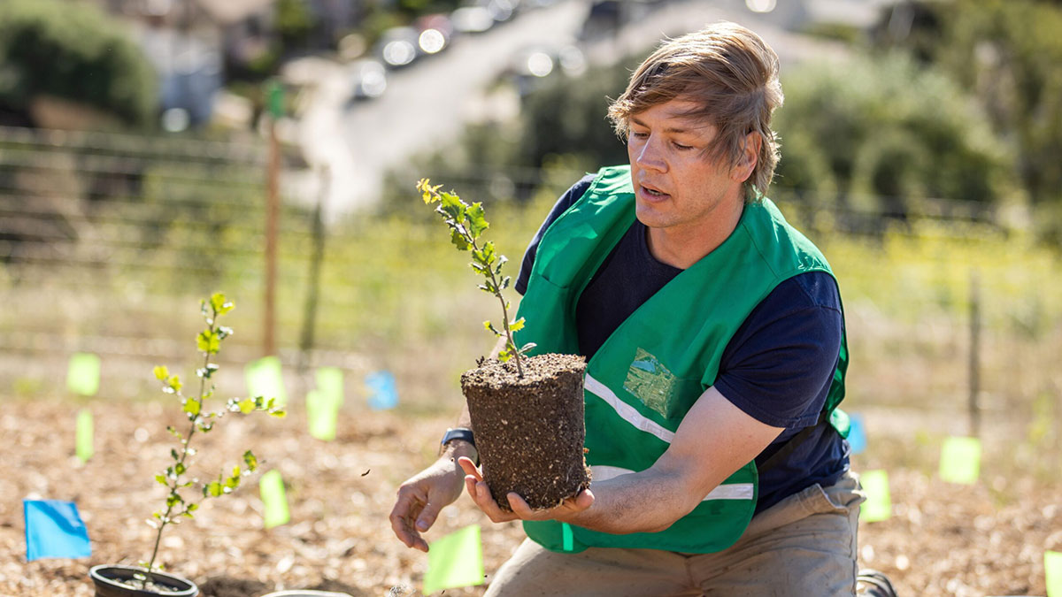 LMU Biology Associate Professor Demian Willete planting a micro-forest